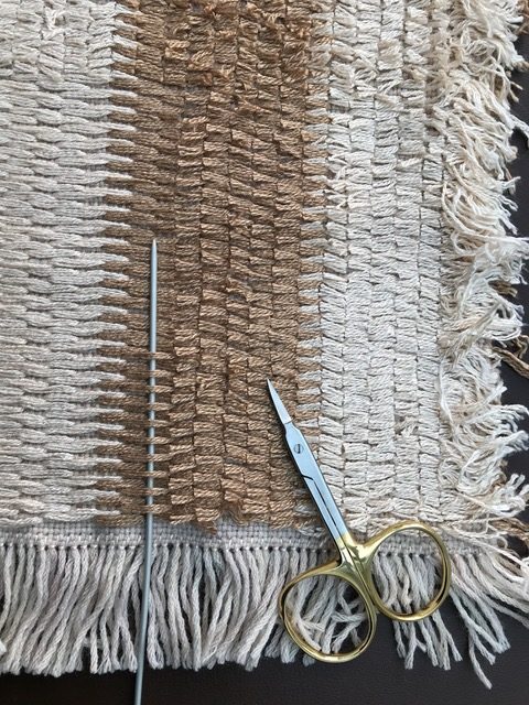Closeup of fabric with needle and scissors
