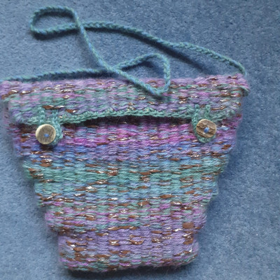 Small bag made of video tape and green, blue and pink yarn.