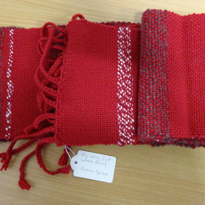 A red scarf with other colours woven in