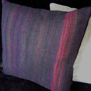 Handwoven cushion in purples and pinks